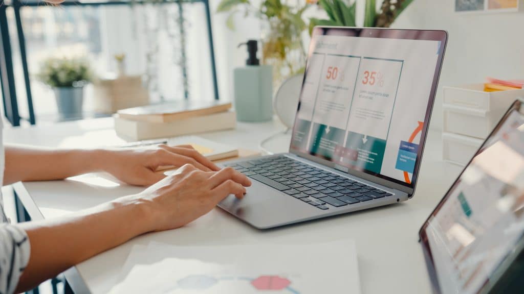 Close-up young asia lady freelance focus on work finance graph account chart market plan in laptop for remote meeting with company at home.