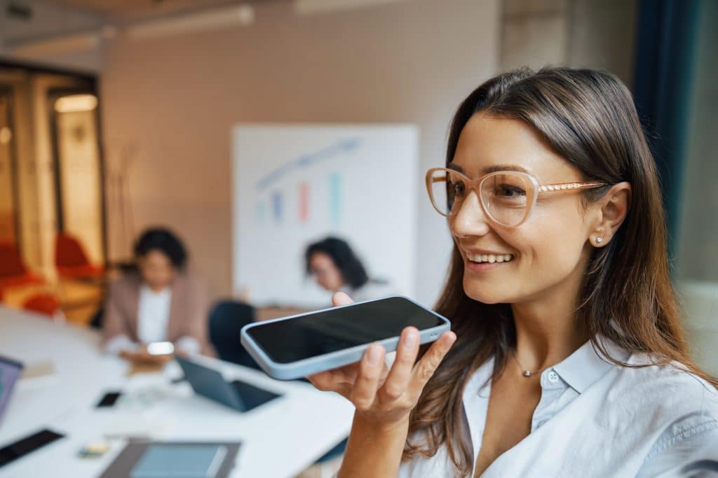 A Businesswoman Effectively Engaged in Voice Command Interaction with Her Smartphone in Office