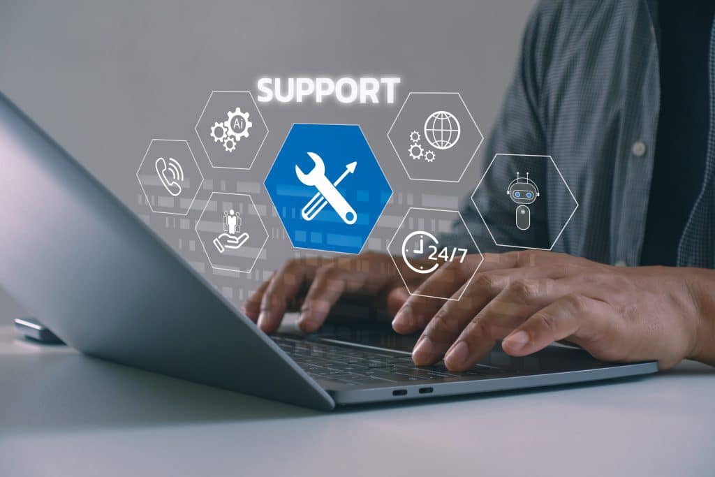 Hands typing on laptop with support icons